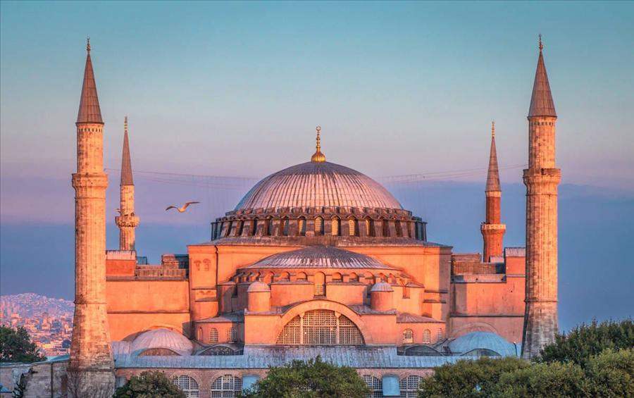 Hagia Sophia and its four minarets glowing pink at sunset, the first stop on an Istanbul airport layover tour