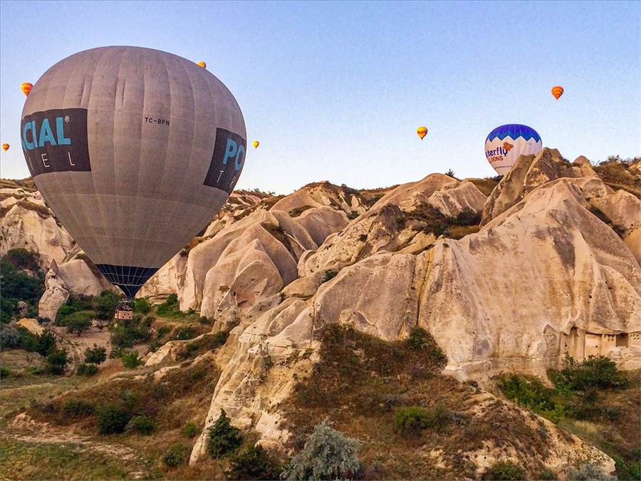 Hot air balloons drifting low between the rock formations of Cappadocia Hot air balloons drifting low between the rock formations of Cappadocia