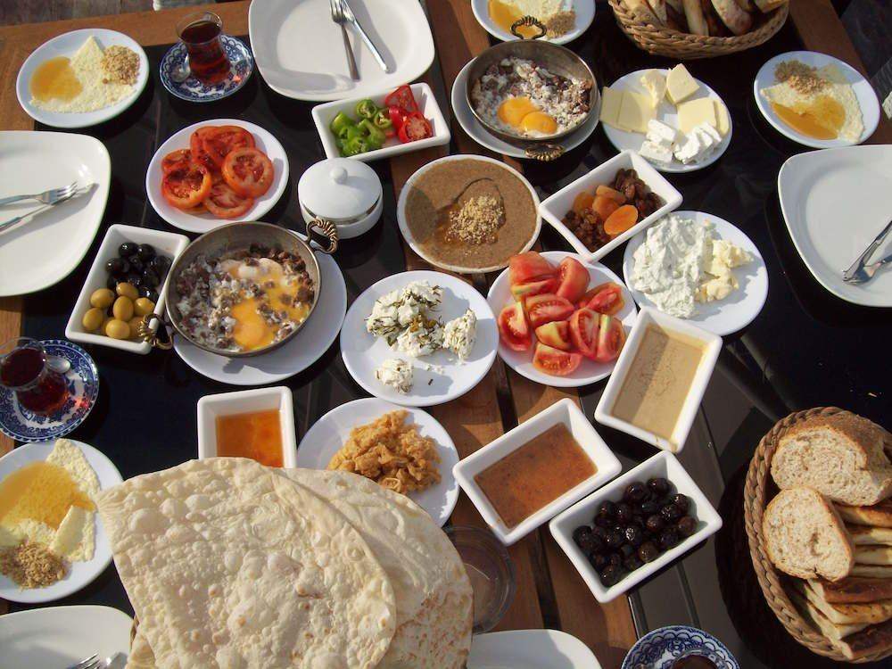 A full Turkish breakfast spread with cheeses, olives, eggs, jams and tea