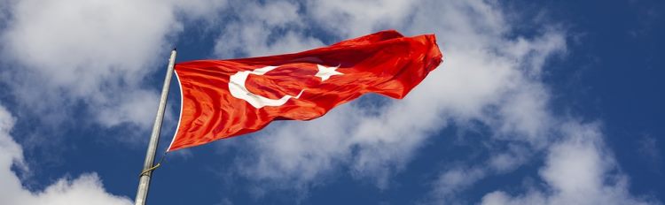 The Turkish flag flying against a clear blue sky